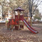 Wooden modular play structure with one tower, slide and climbing unit